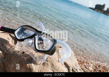 diving equipment resting on a beach rock with sea on background Stock Photo