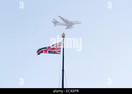 Westminster London, UK. 16th December 2014. An Emirates commercial airplane flies above the Houses of Parliament with the Union Jack © amer ghazzal/Alamy Live News Stock Photo