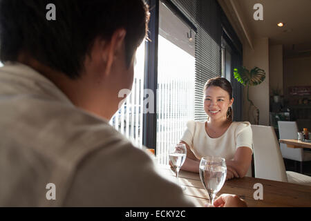 Woman and man sitting at a table in a cafe, smiling. Stock Photo