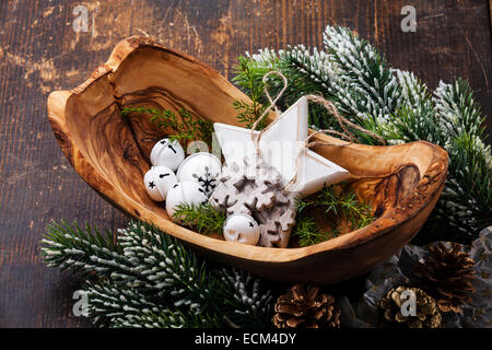 Christmas decorations Bells in olive wood bowl on green fir branches background Stock Photo