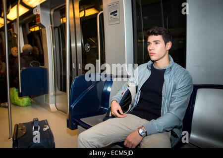 Young man sitting in subway train commuting to work looking away Stock Photo