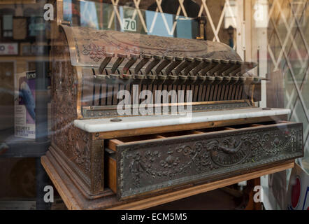 A vintage cash register in the window of a barber shop in downtown Brampton, Ontario, Canada. Stock Photo