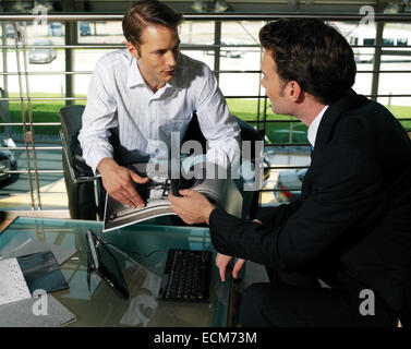 Group of young business people sitting around table on office terrace Stock Photo