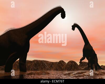 Two brachiosaurus dinosaurs silhouettes in water next to mountains by sunset Stock Photo