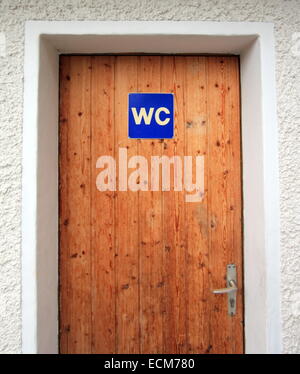 Close up on closed wooden door with WC sign Stock Photo
