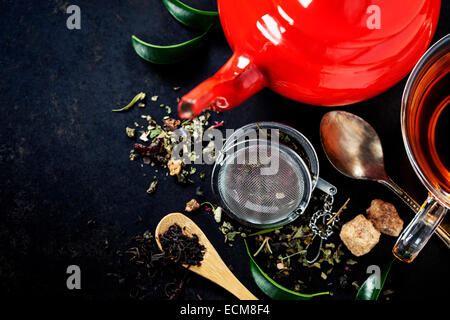 Tea composition with red teapot on dark background Stock Photo