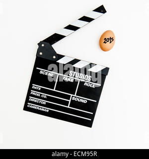 An egg signed as 2015 and movie clapper board on white background Stock Photo