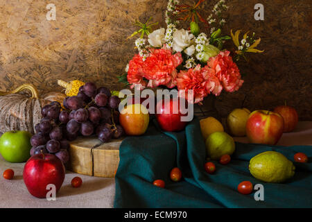 Still life with Fruits were placed together with a vase of flowers beautifully. Stock Photo