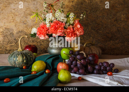 Still life with Fruits were placed together with a vase of flowers beautifully. Stock Photo