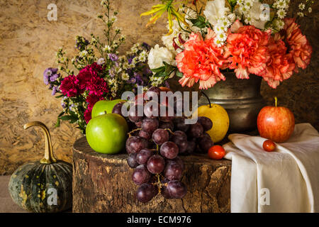 Still life with Fruits were placed together with a vase of flowers beautifully. Stock Photo