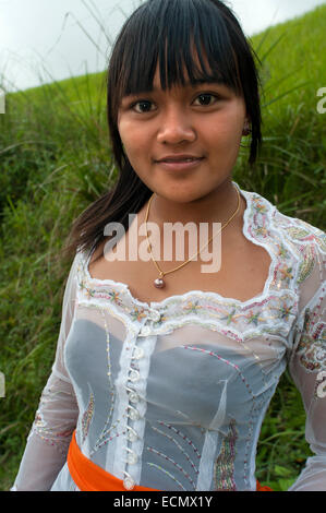 A girl next to rice fields that accompany the walk Campuan crest. Ubud. Bali. On the Campuan ridge walk in Ubud, Bali, beautiful green rice terraces and coconut palm trees dot the Campuan River. Stock Photo