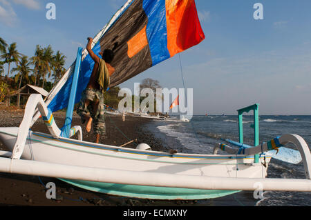 Some fishermen take their boats to the shore near the beach of Amed, a fisherman village in East Bali. Amed is a long coastal st Stock Photo