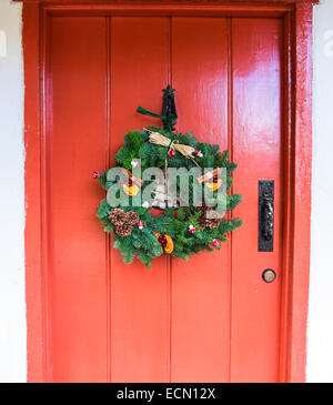 Christmas decorative wreath hung on front door knocker Stock Photo