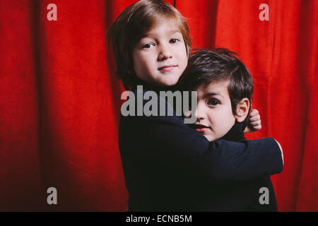 Two boys wearing black clothes on a hug Stock Photo