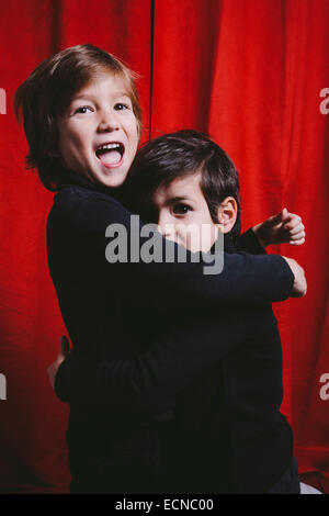 Studio portrait of two boys wearing black clothes on a hug Stock Photo