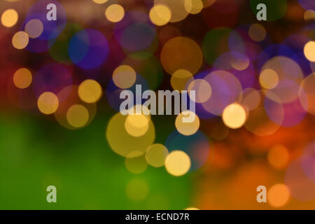 Blurred 'New Year' Christmas tree lights background in warm colours of gold green purple and orange Stock Photo