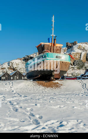 Hastings fishing boats moored on Stade Beach after a snowfall. East Sussex. UK Stock Photo