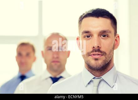 serious businessman in office with team on back Stock Photo
