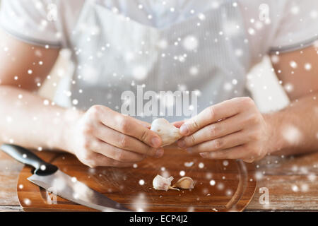 close up of male hands taking off garlic peel Stock Photo