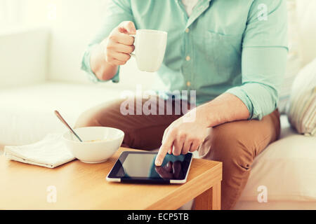 close up of man with tablet pc having breakfast Stock Photo