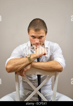 Handsome male model sitting on the chair. Stock Photo