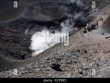 MT. ETNA, SICILY, ITALY - SEPTEMBER, 28, 2012: A tour group looks at one of the steaming crater of the highest active volcano in Stock Photo