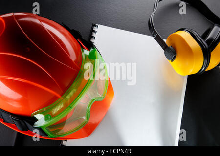 Safety goggles, earphones and red helmet in closeup Stock Photo