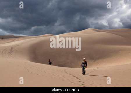 Visitors hike in GREAT SAND DUNES NATIONAL PARK which contains the largest sand dunes in North America - COLORADO MR Stock Photo