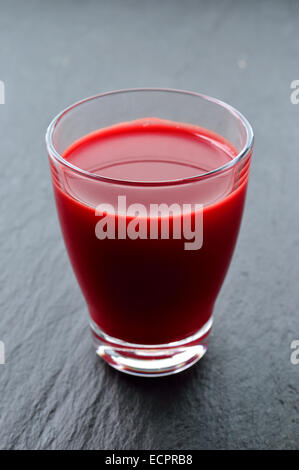 Beetroot, carrot and apple freshly pressed juice in glass on dark background. Healthy raw vegetable and fruit drink for detox. C Stock Photo