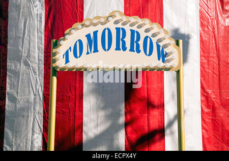 Tomorrow sign against red and white circus tent Stock Photo