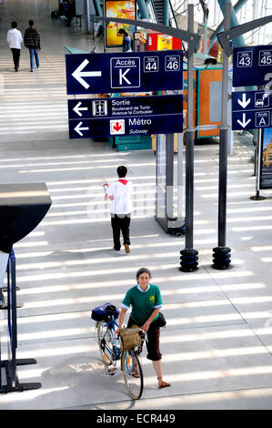 Lille, Pas de Calais, France. Gare de Lille Europe (railway station serving Eurostar trains) - passenger wheeling a bike Stock Photo