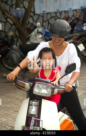 Mother and child riding a motor scooter together in Nha Trang, Vietnam. Stock Photo