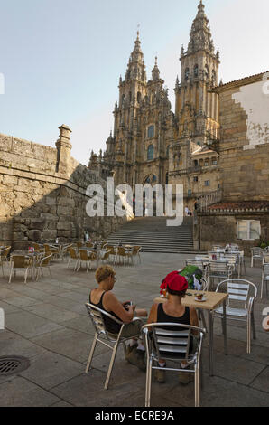 SANTIAGO DE COMPOSTELA, SPAIN – SEPTEMBER 8, 2012: Two pilgrims rest sit in a cafe located before the Cathedral after reaching S Stock Photo