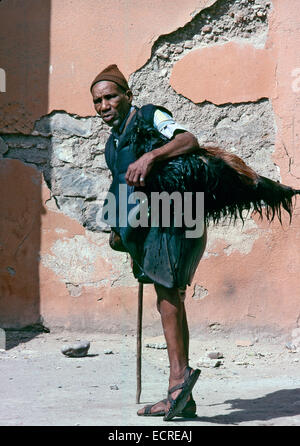 MARRAKECH, MOROCCO – AUGUST, 1979: A water seller carries a bottle of goatskin water for sale on August, 1979 in Marrakech, Moro Stock Photo