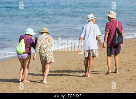 Elderly Spanish couples walking on beach in Spain Stock Photo