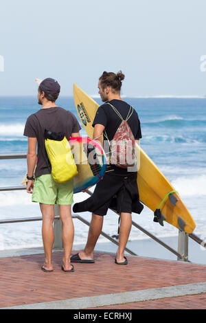 Surfers looking out to sea Stock Photo