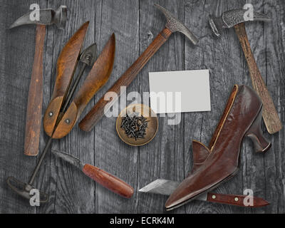 vintage ladies shoe and shoemakers tools over wooden table, space for your text on a blank business card Stock Photo