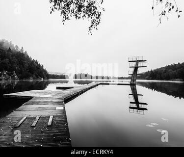 Wooden dock and diving boards on a tranquil lake Stock Photo