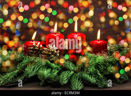 advent decoration with four red burning candles and colorful lights. selective focus, vintage style toned picture. holidays back Stock Photo