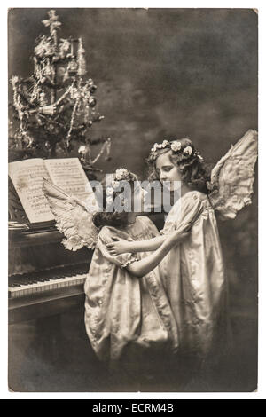 sweety angel girls with white wings and christmas tree. vintage picture with original film grain and blur Stock Photo