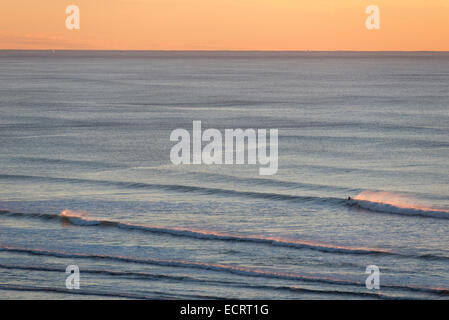 Surfing at sunset on the Oregon Coast. Stock Photo