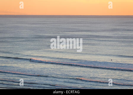 Surfing at sunset on the Oregon Coast. Stock Photo