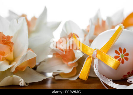 Easter eggs and daffodils on a wood table Stock Photo