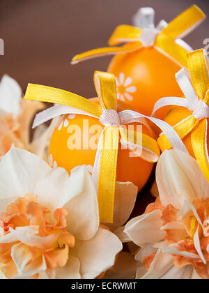 Easter eggs and daffodils on a wooden table Stock Photo