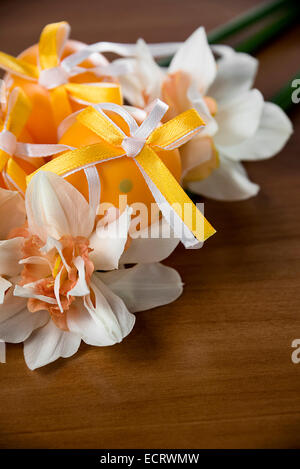 Easter eggs and daffodils on a wooden table Stock Photo