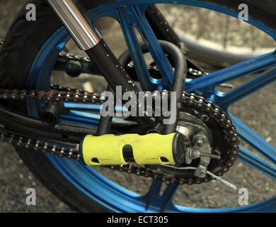 Close up of yellow closed padlock on blue modern wheel Stock Photo