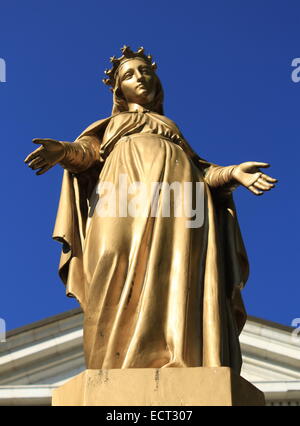 Golden virgin Mary statue in front of a Stock Photo