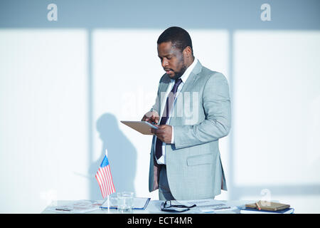 Young businessman in elegant suit using touchpad Stock Photo
