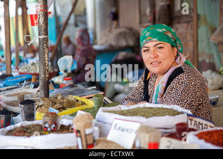 Kyrgyz woman wearing headscarf selling spices at the market in Osh, Kyrgyzstan Stock Photo