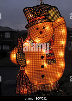 An electric snowman on a window, lit up for Christmas Stock Photo